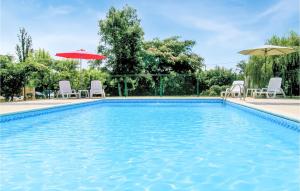 a swimming pool with chairs and umbrellas in a yard at Riverside Retreat in La Barde