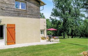 a house with a red umbrella next to a yard at Riverside Retreat in La Barde