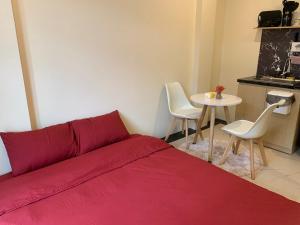 a bedroom with a red bed and a table at Mino Homestay in Hanoi