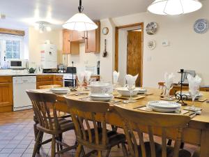 a kitchen with a wooden table with chairs around it at The Old Smithy in Llanbadarn-fynydd