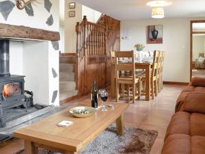 a living room with a table and a fireplace at Ty Hir-bwlch Gwyn Farm Equestrian Centre in Fairbourne