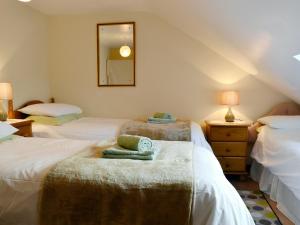 a bedroom with three beds with towels on them at Ty Hir-bwlch Gwyn Farm Equestrian Centre in Fairbourne