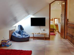 a living room with a tv on the wall at Ty Hir-bwlch Gwyn Farm Equestrian Centre in Fairbourne