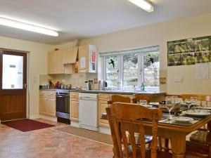a kitchen with a table and a dining room at Blackbird Cottage in Llanfair Caereinion