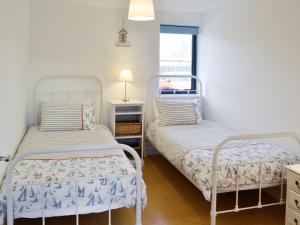 a bedroom with two beds and a window at Sea Drift in West Bay