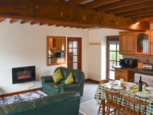 a living room with a couch and a table at Hen Stabl - 16983 in Brynsiencyn