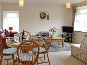 een woonkamer met een tafel en stoelen en een bank bij Pennan Lodge - 26818 in Pennan