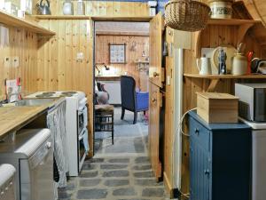 a kitchen with wooden walls and a stove top oven at Crovie in Gardenstown