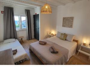 ein Schlafzimmer mit 2 Betten und Handtüchern darauf in der Unterkunft Cantinho de Milfontes in Vila Nova de Milfontes