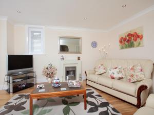 a living room with a couch and a tv at The Avoncliffe Bournemouth in Southbourne