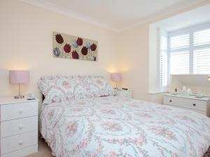 a white bedroom with a bed and two night stands at The Avoncliffe Bournemouth in Southbourne