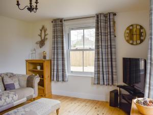 a living room with a couch and a window at Devonia in Newchurch