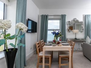 a dining room with a table and chairs and a room with a window at The Cliff Top, Torquay in Torquay