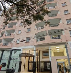 un gran edificio rosa con una motocicleta estacionada frente a él en Paris Tower Apart 81 Departamentos en Resistencia