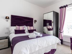 a bedroom with a large bed with towels on it at The Cliff Top, Torquay in Torquay