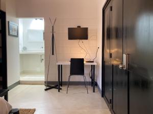 a room with a table with a chair and a television at Casa Ines in Santa Marta