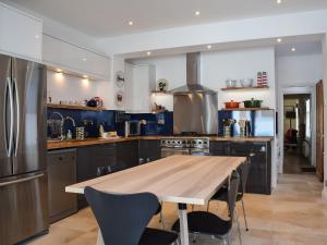 a kitchen with a wooden table with chairs and a refrigerator at Lapwing in Yarmouth