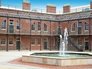 a fountain in front of a brick building at The Sergeants Quarters, Golden Hill Fort in Freshwater