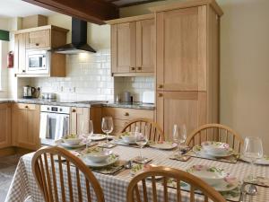 uma cozinha com uma mesa com copos de vinho em Stybarrow View Cottage em Glenridding