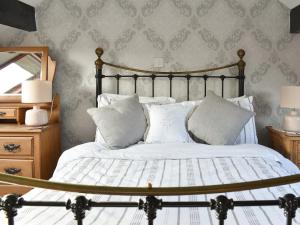 a bedroom with a bed with white sheets and pillows at Stybarrow View Cottage in Glenridding