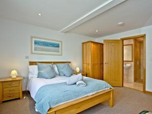 1 dormitorio con 1 cama con manta azul en Sea Glimpses en Saint Columb Minor