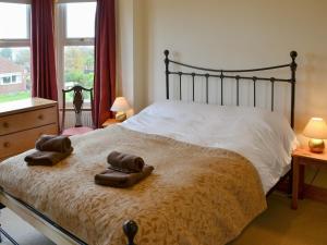 ein Schlafzimmer mit einem Bett mit zwei Handtüchern darauf in der Unterkunft Pembroke House in Happisburgh