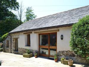 a small stone cottage with a large glass door at The Old Wash House in Pentewan