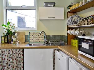 Trecarne Cottage في Saint Cleer: مطبخ مع حوض و كونتر توب