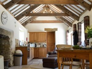 a kitchen with wooden ceilings and a table in a room at The Old Wash House in Pentewan