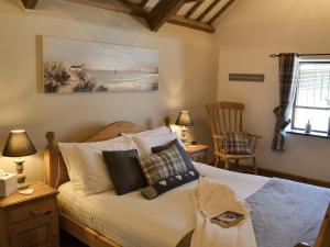 a bedroom with a bed with pillows on it at The Old Wash House in Pentewan
