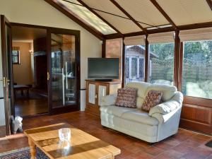 un soggiorno con divano e TV di Maytree Cottage a East Dereham
