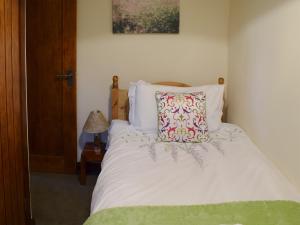 a bedroom with a bed with a pillow on it at Hazel Cottage in Ambleside