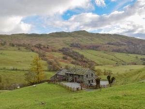 an old house on a hill in a field at Hazel Cottage in Ambleside