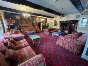 Duvale Priory - 9985 في Bampton: غرفة معيشة كبيرة مع كنب ومدفأة