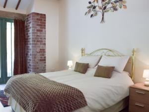 a bedroom with a large white bed with two pillows at The Coach House At Stable Cottage in Derwydd
