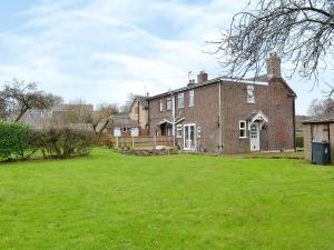 a large brick house with a large yard at Chorlton Moss Cottage in Maer