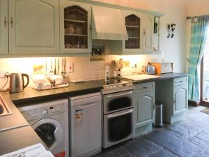 a kitchen with a washer and dryer in it at The Coach House in Tytherton Lucas