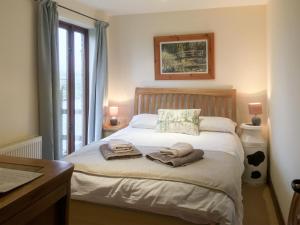 a bedroom with a bed with towels on it at The Coach House in Tytherton Lucas