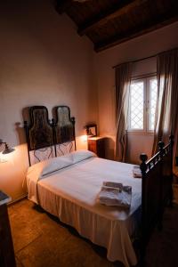 a bedroom with a large bed and a window at Baglio il Gelso e l'Ulivo appartamento il Carrubo in San Lorenzo +40 photos