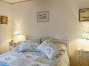 1 dormitorio con 1 cama con almohadas y 2 lámparas en Larachan, en Scarfskerry