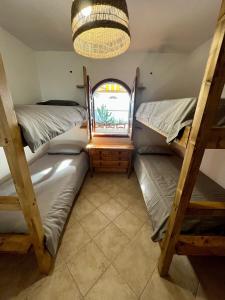 a room with three bunk beds and a window at Pura Vida Surf Camp & School in La Oliva
