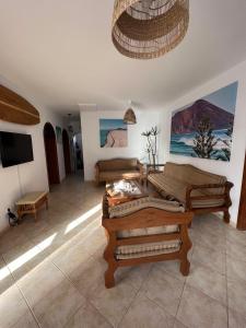 una sala de estar con muebles de madera. en Pura Vida Surf Camp & School en La Oliva