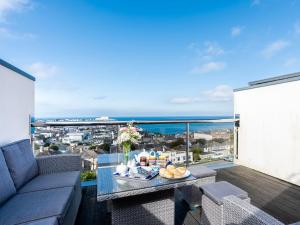 a living room with a couch and a table on a balcony at Above Towan At 8 Quay Court in Newquay