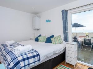 a bedroom with a bed and a window with a patio at Above Towan At 8 Quay Court in Newquay