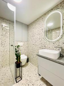 a bathroom with a sink and a mirror at Apartament Piccolo in Bielsko-Biała