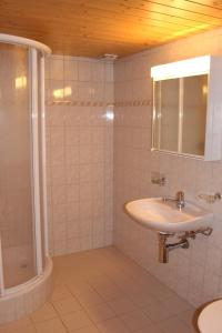 een witte badkamer met een wastafel en een douche bij Chalet Spinne in Grindelwald