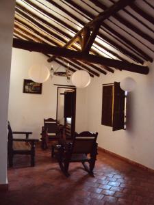 a living room with chairs and a ceiling with beams at El Zaguan in Barichara