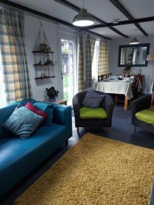 a living room with two blue couches and a table at 3.9. Tudor Court in Hayle