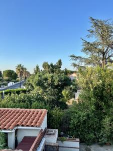 um telhado de uma casa com árvores e uma rua em Les orangers - Villa catalane avec Jacuzzi em Saint-Génis