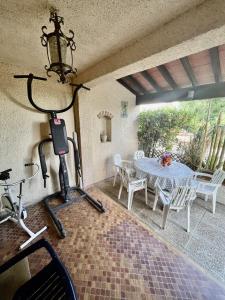 um quarto com uma mesa e uma bicicleta e um quarto com uma sala de jantar em Les orangers - Villa catalane avec Jacuzzi em Saint-Génis